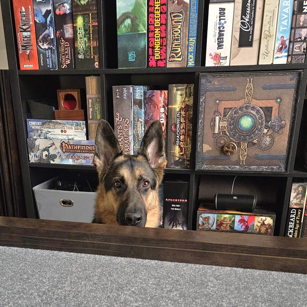 My German Shepherd dog, Wrigley, peeking over the other side of the game table.
